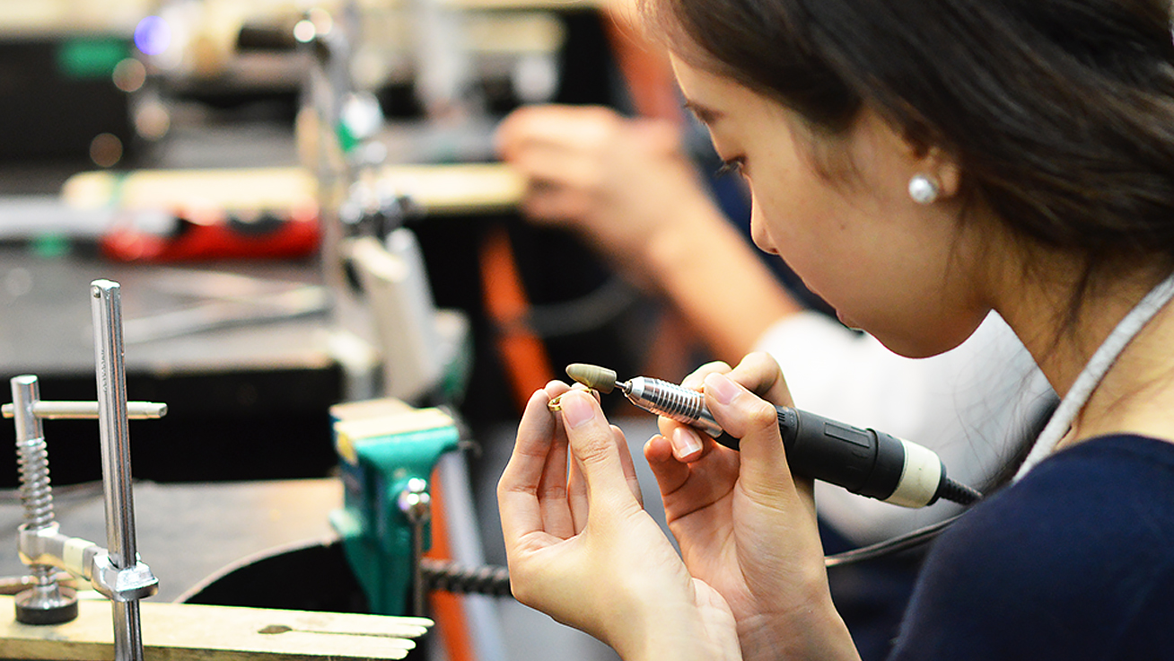 A customer carefully machining a ring at the workshop