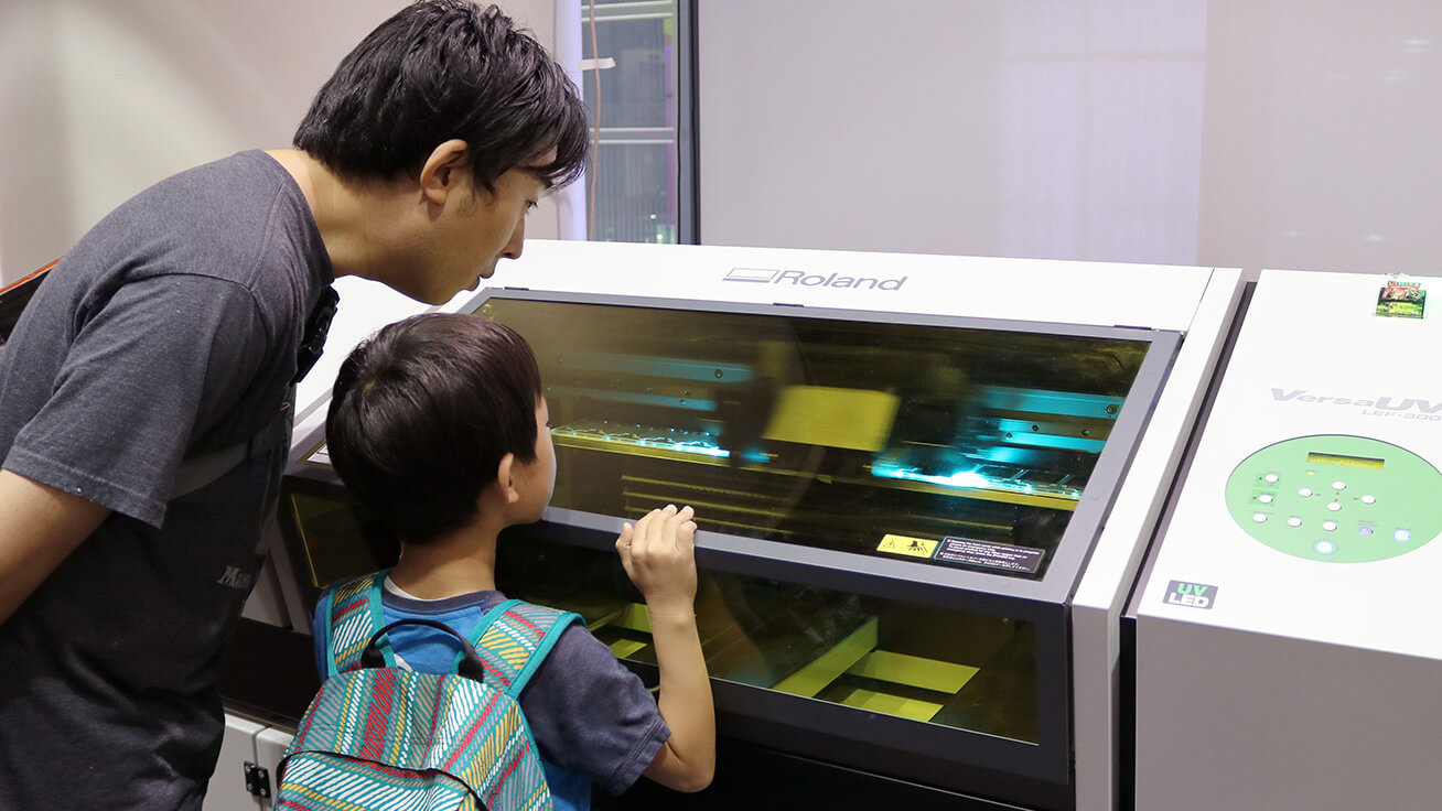 Visitors watching the UV printer in action.