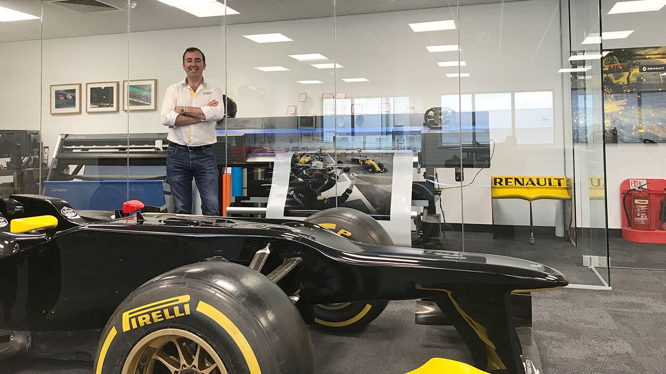 Joe McNamara, Head of Paint and Graphics at Renault Sport Formula One Team, poses with their Roland DG printer/cutter and vinyl cutter.