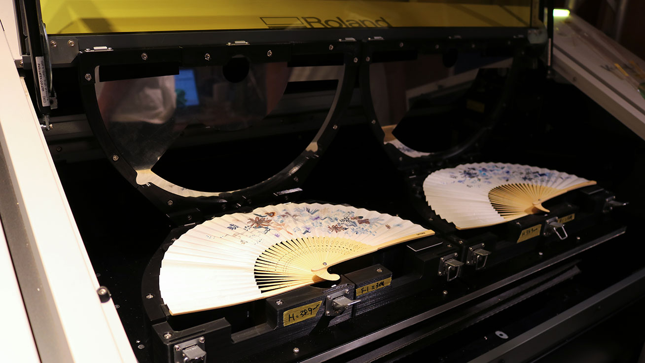 Personalized folding fans being printed at the gallery using UV printers