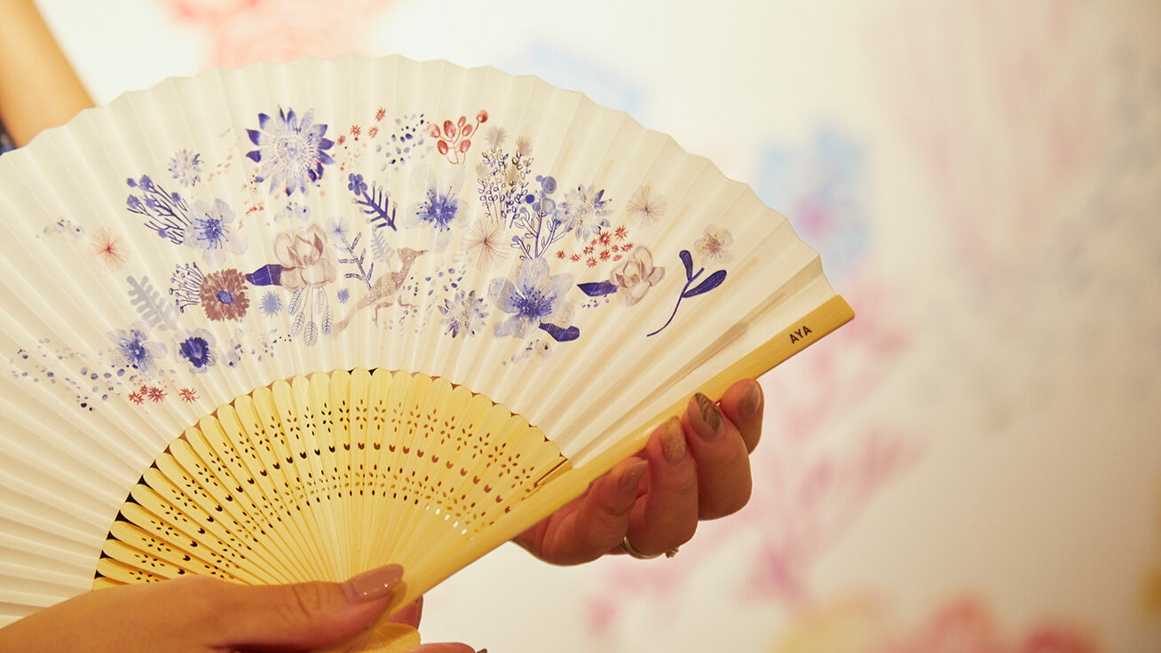 Custom-made folding fan designed to match color patterns in visitors’ clothes