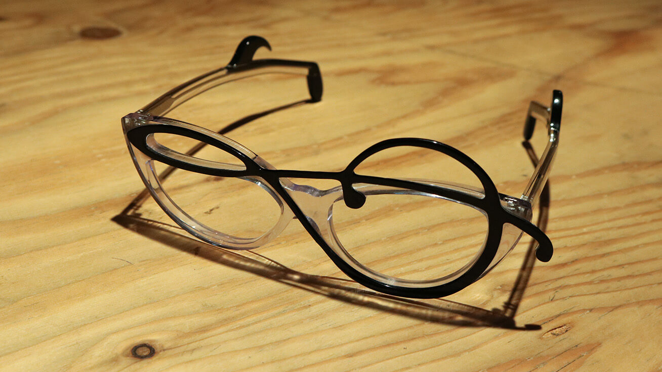 A frame featuring a musical note made from two layers of resin material, black in front and transparent at the back.