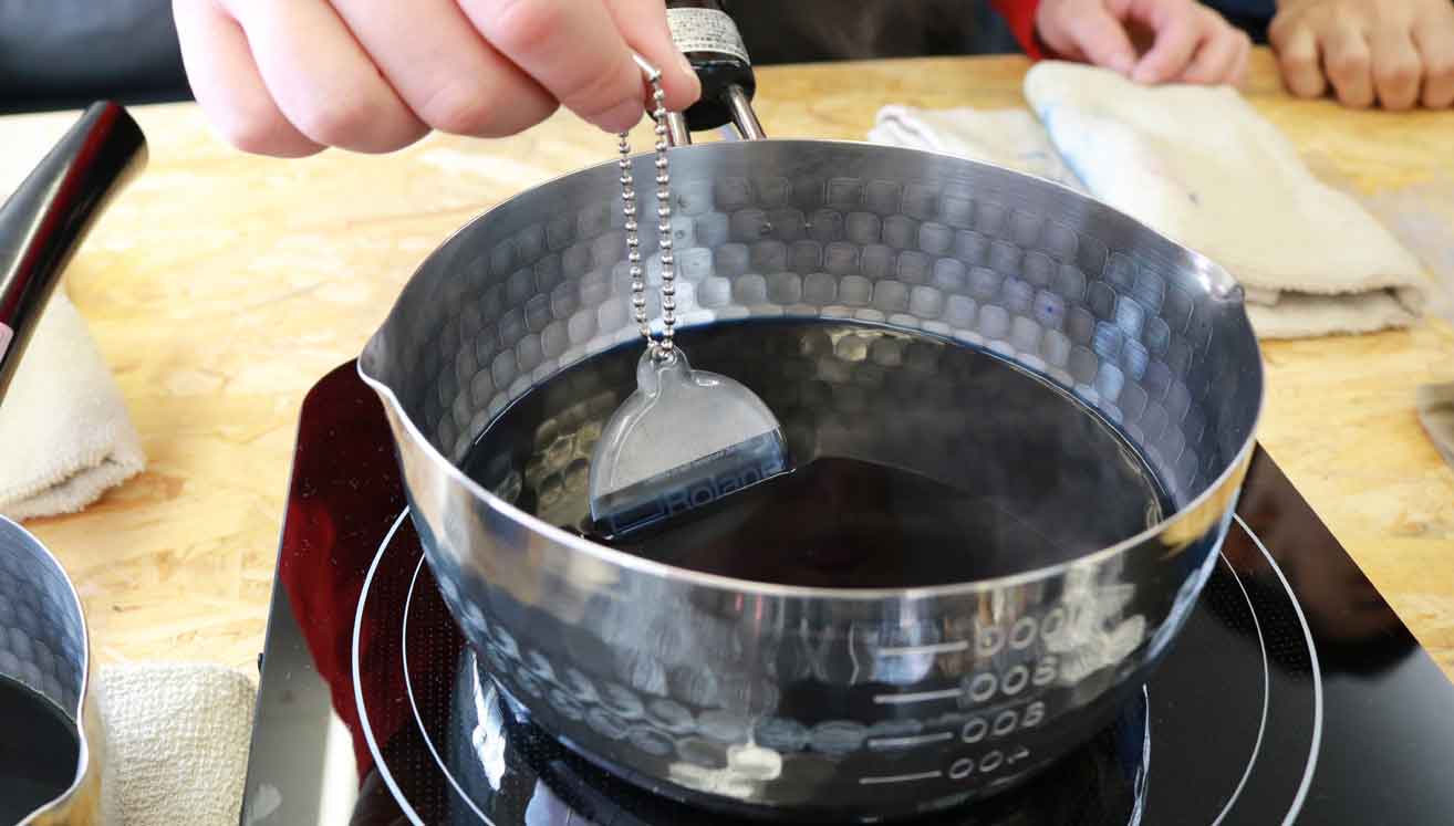 鍋で樹脂用の染料を溶かした水を沸かし、しゃぶしゃぶのようにアクリルを染めていきます