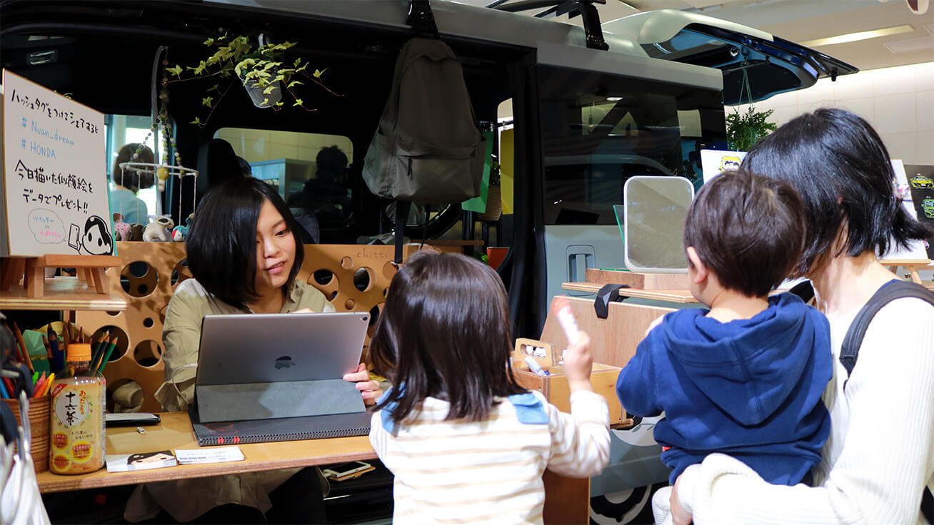 Illustrator Chihiro (left) chats with visitors while drawing their portraits.