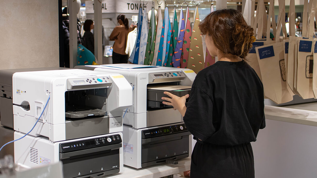 Printing out designs in the booth using the BT-12 direct-to-garment printer.