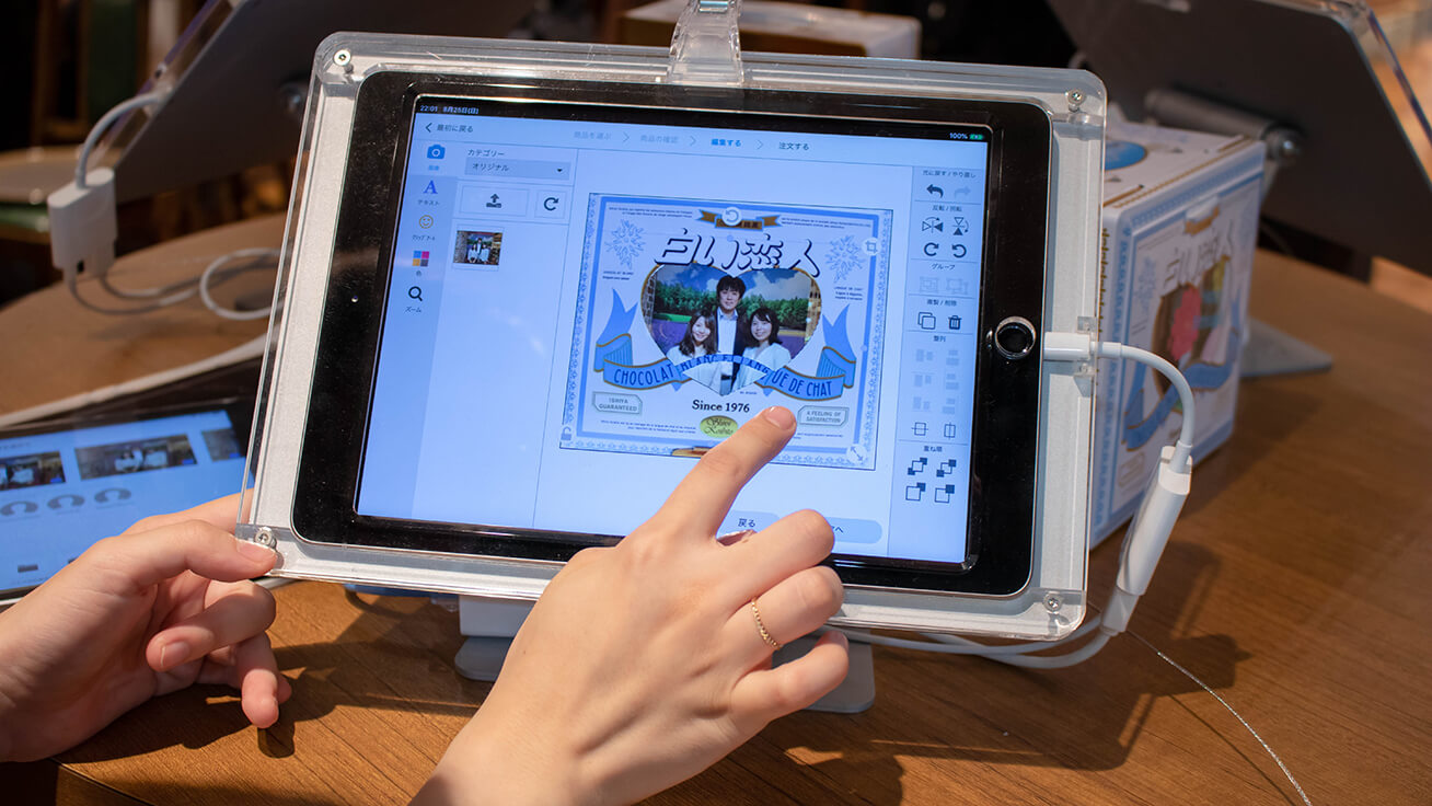 Editing the layout on the tablet screen using cotodesign. Text and stamp artwork can also be added.