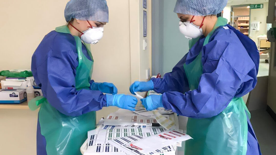 Hospital staff wrote their names on name badges to stick on their PPE.