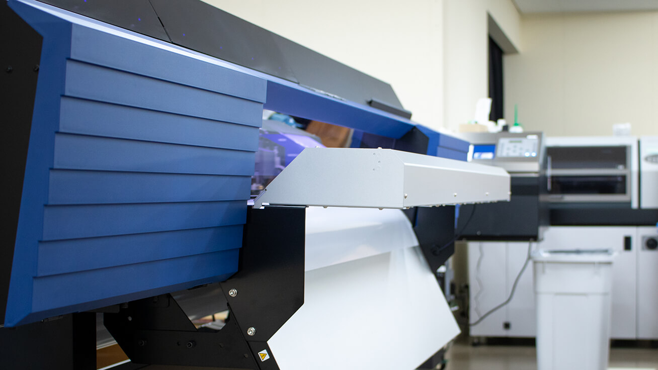 Roland DG’s TrueVIS VG2-540 wide-format printer/cutter (foreground) and VersaUV LEF2-200 UV printer (background) 