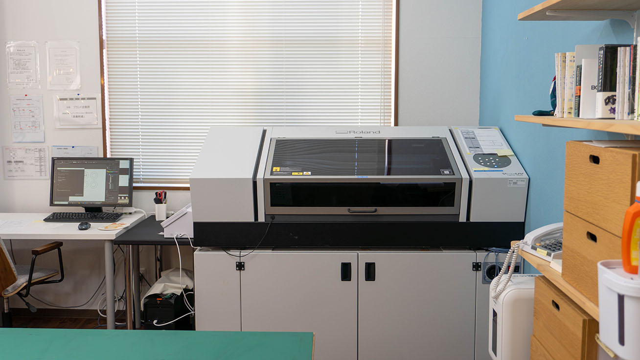 The LEF2-300 benchtop flatbed UV printer installed at the Brand Planning Department office.