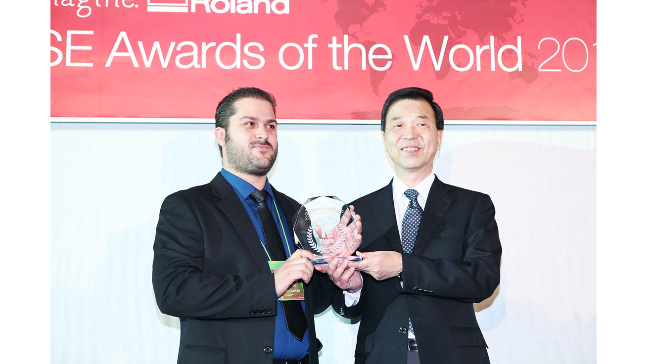 Mr. Yannig Van de Wouwer (left) receives the award from Masahiro Tomioka, President of Roland DG.